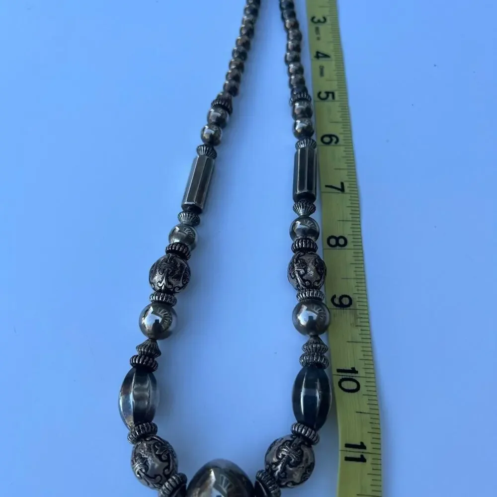 Tarnished silver color beaded necklace. Multiple shapes & sizes of silver color